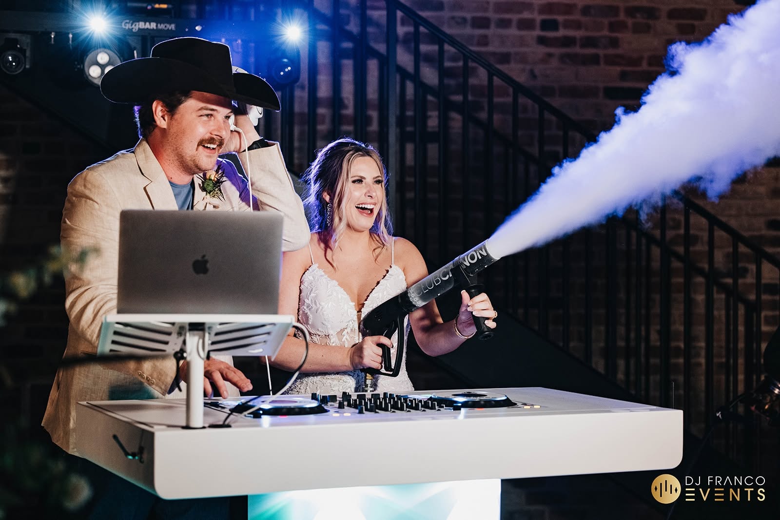 A Texas wedding couple behind the DJ console with the bride manning a CO2 gun.